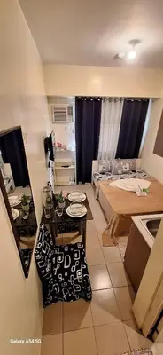 a small room with a bed and a table at g and A condotels in Manila