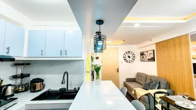 a kitchen and a living room with a couch at Urban Stay with Netflix KTV Wifi and Gym Park in Manila