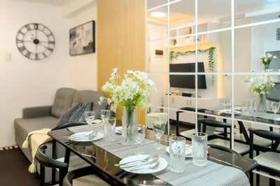 a living room with a table with flowers on it at Urban Stay with Netflix KTV Wifi and Gym Park in Manila