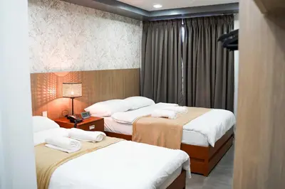 a hotel room with three beds with white sheets at OYO 1168 Gimaca Boutique Hotel & Cafe in Manila