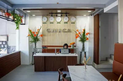 a woman sitting at a desk with a laptop at OYO 1168 Gimaca Boutique Hotel & Cafe in Manila