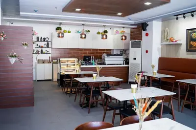 a restaurant with tables and chairs and a kitchen at OYO 1168 Gimaca Boutique Hotel & Cafe in Manila