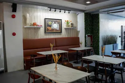 a restaurant with tables and a couch in a room at OYO 1168 Gimaca Boutique Hotel & Cafe in Manila