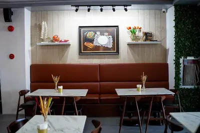 a restaurant with two tables and a brown couch at OYO 1168 Gimaca Boutique Hotel & Cafe in Manila