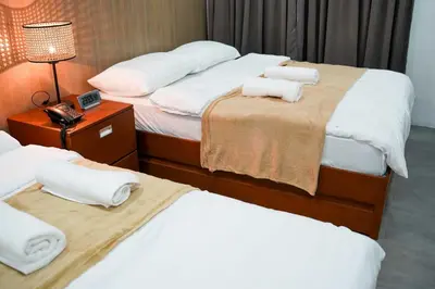 a hotel room with two beds with towels on them at OYO 1168 Gimaca Boutique Hotel & Cafe in Manila
