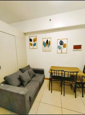 a living room with a couch and a table at Cozy 2BR Stay Near SM Southmall in Manila