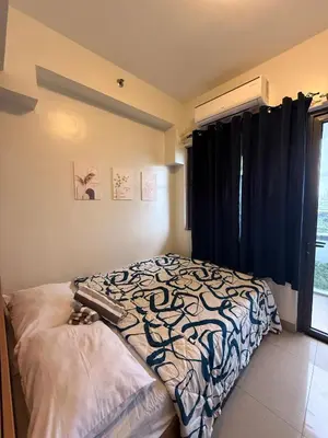 a bedroom with a bed and a large window at Shore 2 Tower 1 Eliel Staycation in Manila