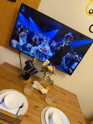 a flat screen tv hanging on a wall above a table at Shore 2 Tower 1 Eliel Staycation in Manila