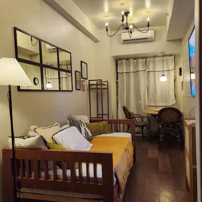 a bedroom with a bed and a table and chairs at MOA Staycation The Baycourt at Shore Residences Near Mall of Asia IKEA NAIA SMX Convention Center MOA Concert Grounds in Manila