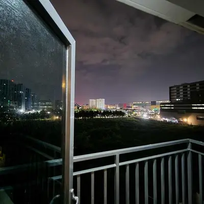 a view of a city at night from a balcony at MOA Staycation The Baycourt at Shore Residences Near Mall of Asia IKEA NAIA SMX Convention Center MOA Concert Grounds in Manila