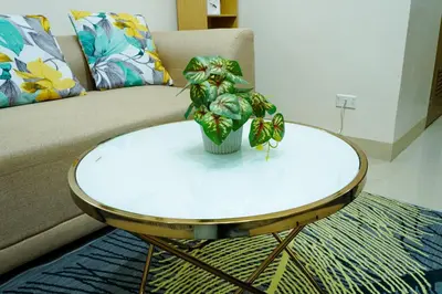 a table with a plant on top of it in front of a couch at Shore 2 Residences near MOA, NAIA, PITX in Manila