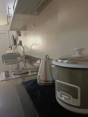 a kitchen with a pot on a stove with a sink at Sea residence in Manila