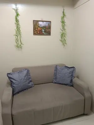 a couch in a room with two plants on the wall at Sea residence in Manila