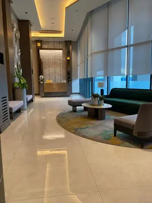 a lobby with a green couch and a table at Bright Condo-Gentry Manor 2 mins to Okada - 6G in Manila