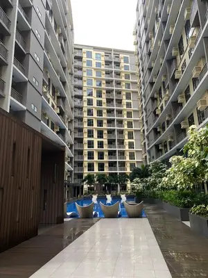 a walkway between two large apartment buildings at Bright Condo-Gentry Manor 2 mins to Okada - 6G in Manila