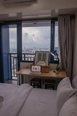 a bedroom with a bed and a desk with a laptop at Business Room, Simple Workation Stay in Manila