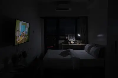 a dark room with a bed and a television at Business Room, Simple Workation Stay in Manila