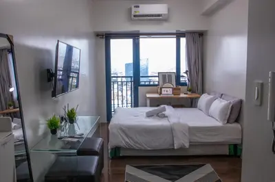 a bedroom with a bed and a glass table at Business Room, Simple Workation Stay in Manila