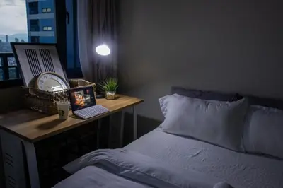 a bedroom with a bed and a desk with a laptop at Business Room, Simple Workation Stay in Manila