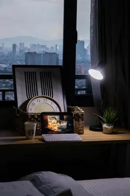 a desk with a laptop and a clock and a window at Business Room, Simple Workation Stay in Manila