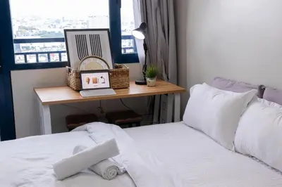 a bedroom with a desk with a laptop on a bed at Business Room, Simple Workation Stay in Manila