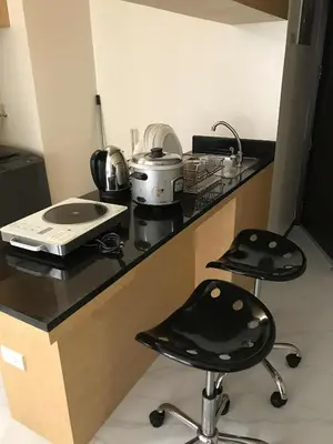 a kitchen counter with two stools in a room at A venue Residences 2013 in Manila