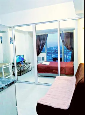 a bedroom with a bed and a large window at Azure Staycationcation by Nairah in Manila