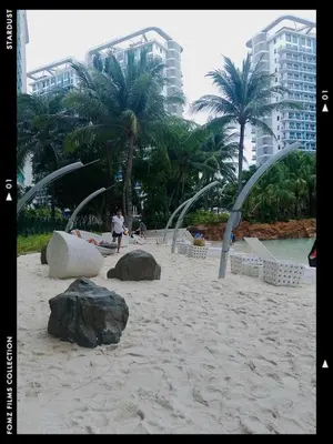 a beach with rocks and palm trees and buildings at Azure Staycationcation by Nairah in Manila