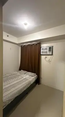 a small bedroom with a bed and a air conditioner at Shore Residecnes Infront of MoA, Netflix, Wifi in Manila