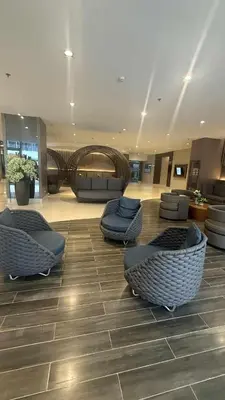 a lobby with couches and chairs in a building at Shore Residecnes Infront of MoA, Netflix, Wifi in Manila