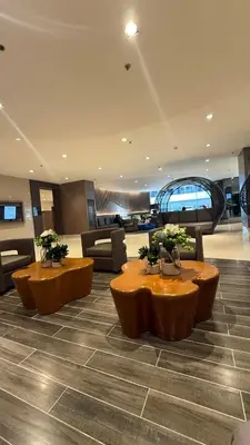 a lobby with couches and a table with trees on it at Shore Residecnes Infront of MoA, Netflix, Wifi in Manila