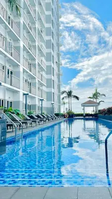 a large swimming pool in front of a building at Jessa Rios Coast Staycation 2 in Manila