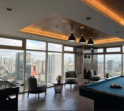 a pool table in a room with a view of a city at Jessa Rios Coast Staycation 2 in Manila
