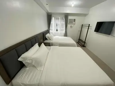a bedroom with two beds and a flat screen tv at 1BR 2 Beds Family Friendly near MOA - 9119C in Manila