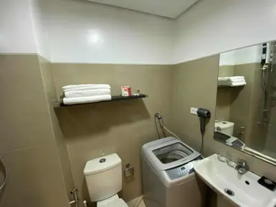 a bathroom with a toilet and a sink and a mirror at 1BR 2 Beds Family Friendly near MOA - 9119C in Manila