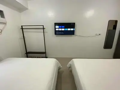 a room with two beds and a tv on the wall at 1BR 2 Beds Family Friendly near MOA - 9119C in Manila