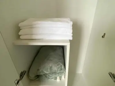 a group of towels on a shelf in a bathroom at Bright Unit with Balcony near Okada & Airport-6C in Manila