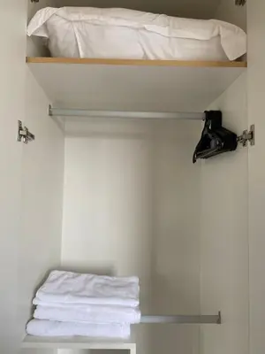 a closet with a bed and towels on a shelf at Bright Unit with Balcony near Okada & Airport-6C in Manila