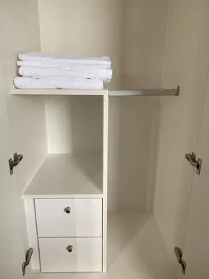a white shelf with towels on it in a bathroom at Bright Unit with Balcony near Okada & Airport-6C in Manila