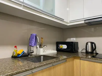 a kitchen counter with a sink and a microwave at Bright Unit with Balcony near Okada & Airport-6C in Manila