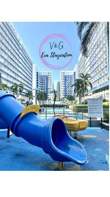 a blue slide in a playground with buildings in the background at V&G Era Staycation in Manila
