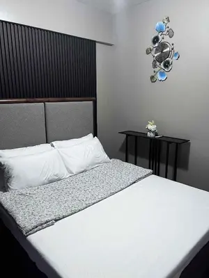 a bedroom with a white bed with two side tables at The Haru at Arista in Manila