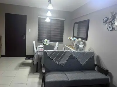 a living room with a gray couch and a table at The Haru at Arista in Manila
