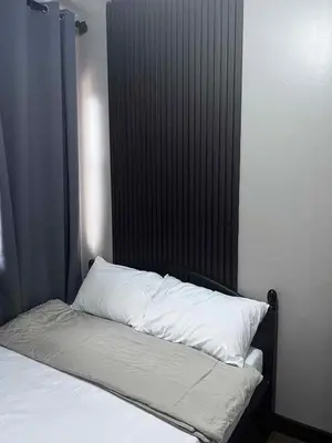 a bed with a black headboard and white pillows at The Haru at Arista in Manila
