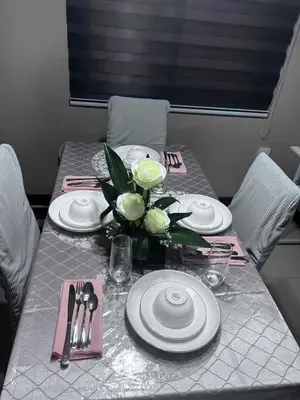 a table with plates and a vase of flowers on it at The Haru at Arista in Manila