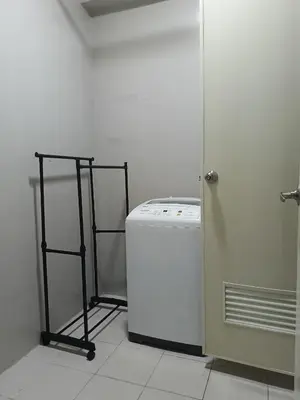 a white laundry room with a washing machine and a door at WP1102 Facing pool view near MOA in Manila