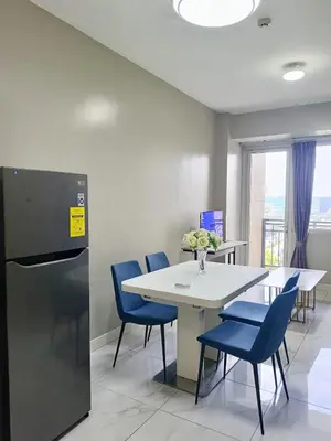 a dining room with a white table and blue chairs at WP1015 with Balcony in Manila