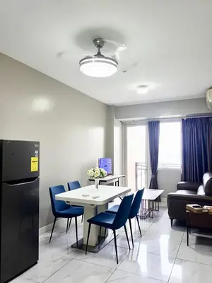 a dining room with a table and blue chairs at WP1015 with Balcony in Manila
