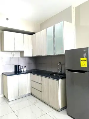a kitchen with white cabinets and a stainless steel refrigerator at WP1015 with Balcony in Manila
