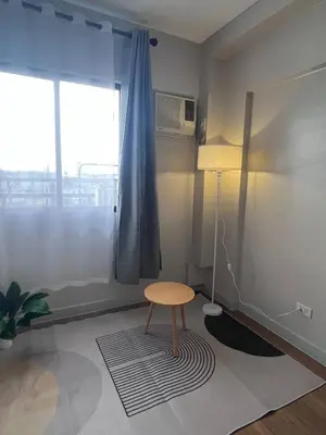 a room with a table and a chair and a window at Resort inspired Alea residences in Manila